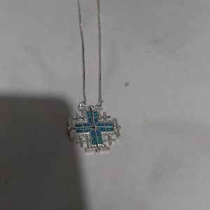 A cross with light blue on it and silver